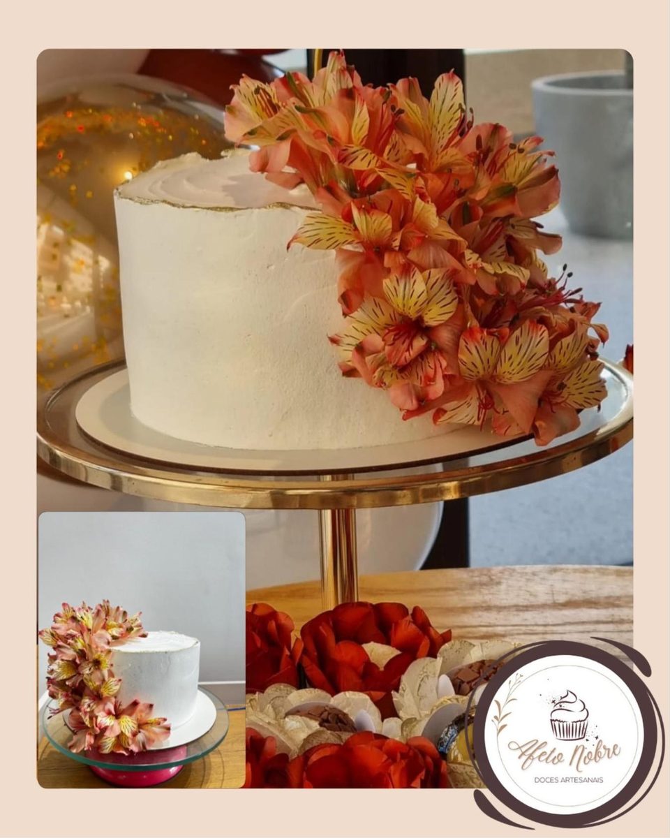 Bolo branco com flores alaranjadas sobre suporte dourado, com docinhos em forminhas de flor e uma foto menor do mesmo bolo